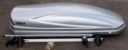 A Thule car roof box with Thule roof bar