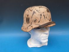 A German SS helmet with winter camouflage finish, SS logo to right hand side and marked to interior