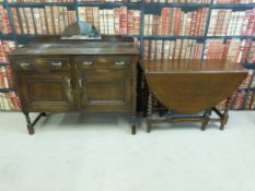 An oak drop-leaf table together with an oak sideboard