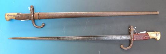 A French bayonet in scabbard, marked St Etiene 1875 to back of blade, together with a similar