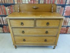 An oak dressing chest with four drawers with drop handles