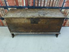 A 16th /17thC elm coffer with carved and fluted edging raised on single plank legs united by W