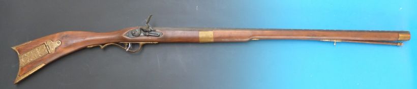 A replica flintlock rifle with engraved brass mounts and hexagonal barrel