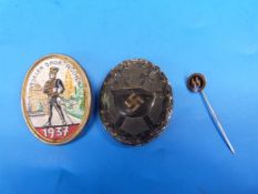 A Nazi SS wound badge together with an SS stick pin and a German embroidered badge marked Weseler