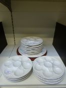 Twelve relief moulded oyster plates and another on a hardwood stand