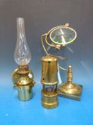 A brass desk magnifying glass, ship's brass wall oil lamp and a miner's lamp