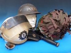 A collection of four helmets including a riot helmet, a Military Police helmet, an American Vietnam