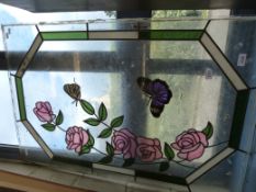 A stained glass window decorated with butterflies among roses (103cm x 67cm)