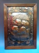 An oak framed Arts and Crafts copper plaque depicting cherubs