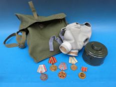 Five Soviet c1970's medals and a gas mask in canvas bag