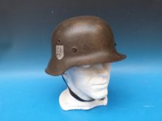 A German WW2 SS combat helmet with logo to right hand side, stamped to interior 342 with period