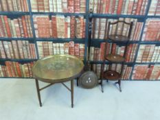A folding mahogany cake stand, a brass-topped table and a copper warming pan