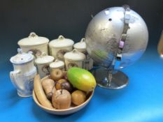 A world globe on chrome stand together with a quantity of wooden fruit in a  bowl, a set of kitchen