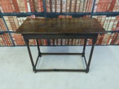 A 17th / 18thC peg jointed oak side table raised on turned legs united by four hard chamfered