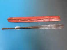 A paddle shaped tribal weapon in red leather sheath