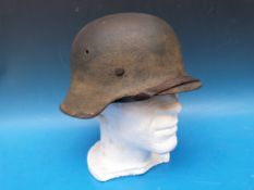 A German Luftwaffe camouflage helmet with faint eagle to left hand side and stamped to rim