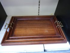 A set of three graduated mahogany trays with brass handles