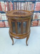 A circular glazed display cabinet with tray top