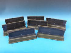 Seven tank periscopes all marked with serial numbers and other military markings.