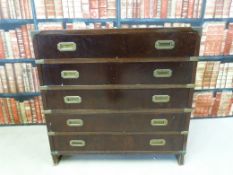 A military style secretaire chest with tooled leather top and fall flap top drawer over four