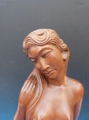 A carved hardwood large figure of a semi-clad female