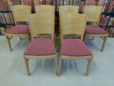 A set of six upholstered beech chairs with pierced shaped backs and bentwood stretchers