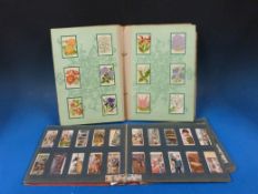 A complete album of Kensitas silk flowers and an album of cigarette cards, including naval