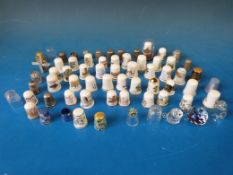 A collection of ceramic, metal and glass thimbles to include three silver thimbles