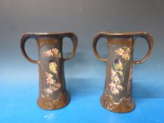 A pair of Bretby Pottery Art Nouveau copperette twin handled vases with hand decorated panels of
