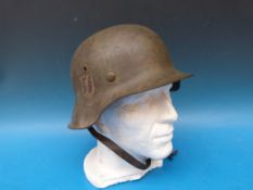 A German WW2 SS combat helmet with logo to right hand side and stamped to interior (possibly FF 64