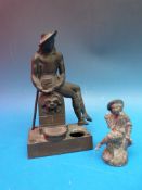 A bronze inkwell formed as a seated figure on a fountain, together with a small lead model of a boy