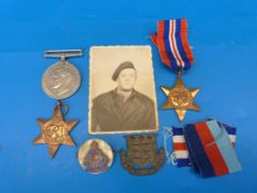 A group of three WWII medals in original box together with an Army Ordinance Corps plaque and