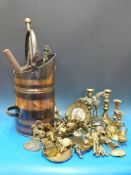 A copper coal scuttle, companion set, brass candlesticks and a large quantity of brass ornaments,