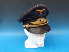 A German Luftwaffe general's visor cap with gold ribbon and emblems. Label inside for Fenrich & Co,