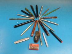 A quantity of fountain pens and propelling pencils including Burnham Waterman and Parker, a rolled