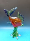 A large Murano multicoloured glass fish raised on green base, 37cm tall.