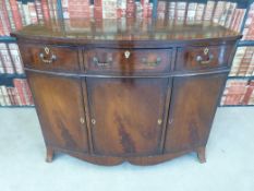 A bow-fronted mahogany cabinet fitted three drawers above cupboard (W107, D54,
