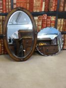 An oval bevelled oak framed mirror and another mirror
