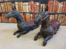 A pair of Eastern lacquer seated horses with gilt decoration,