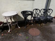 Two Victorian cast iron Britannia table bases together with a circular stone top and three chairs.