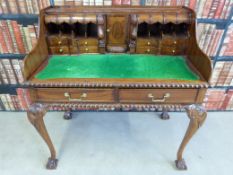 A French walnut desk having drawers, pigeon holes and cupboard to the top,