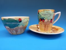 A Clarice Cliff teacup and saucer, decorated in oak leaves and acorns pattern,