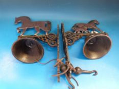 Two cast wall mounted bells with horses on top and another horse