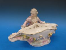 A continental figural sweetmeat dish in the Meissen style, crossed swords over an R to base (18.