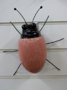A signed Adrian Holt ceramic exotic insect in a dark pink colourway (25cm)
