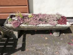 A natural stone trough on stand