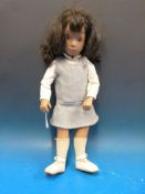 A 1967 Sasha girl doll with painted features, long dark brown hair and jointed limbs,
