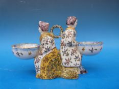 A tin glazed maiolica figural salt. Approximately 11.5cm in height, 18cm in width. Bowls 5.