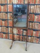 A 19th/20thC mahogany cheval mirror with brass swivel candle sconces to the side and with bevelled