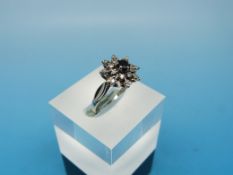 A 9ct white gold ring set with a central sapphire surrounded by diamonds in a cluster